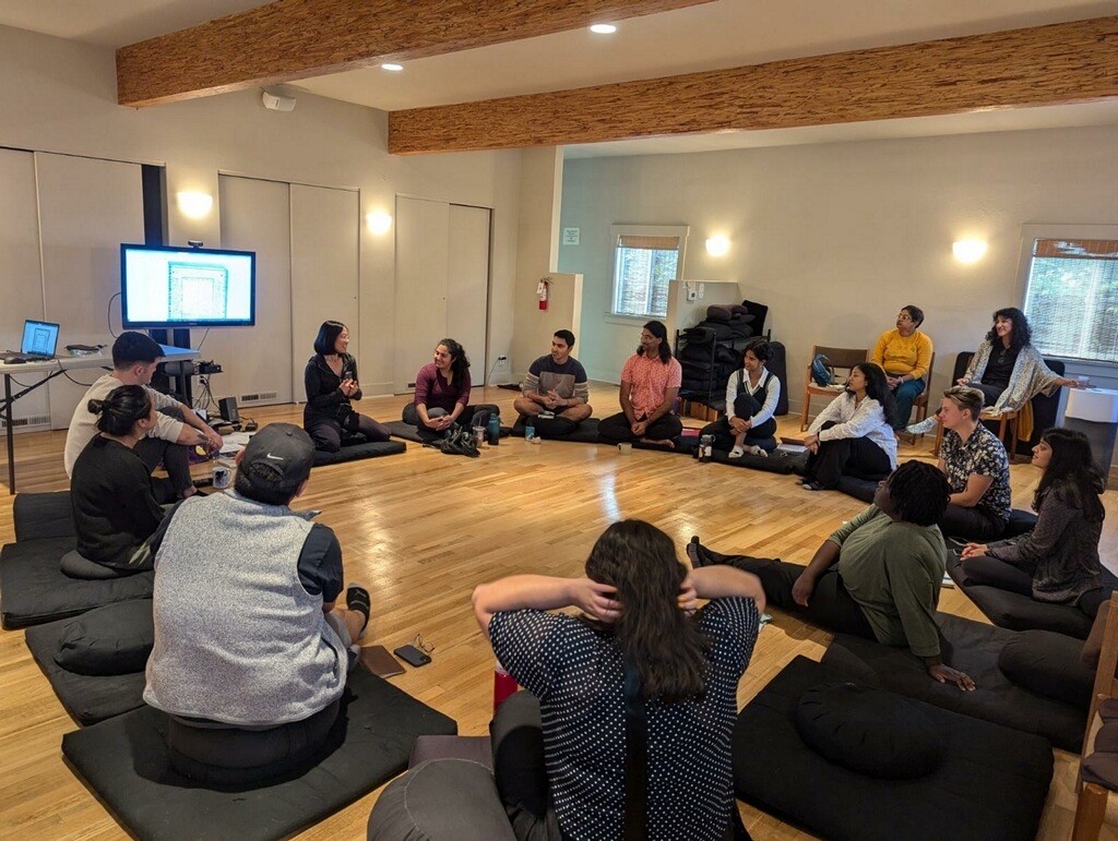 A photo of residents seated in a circle on the floor.