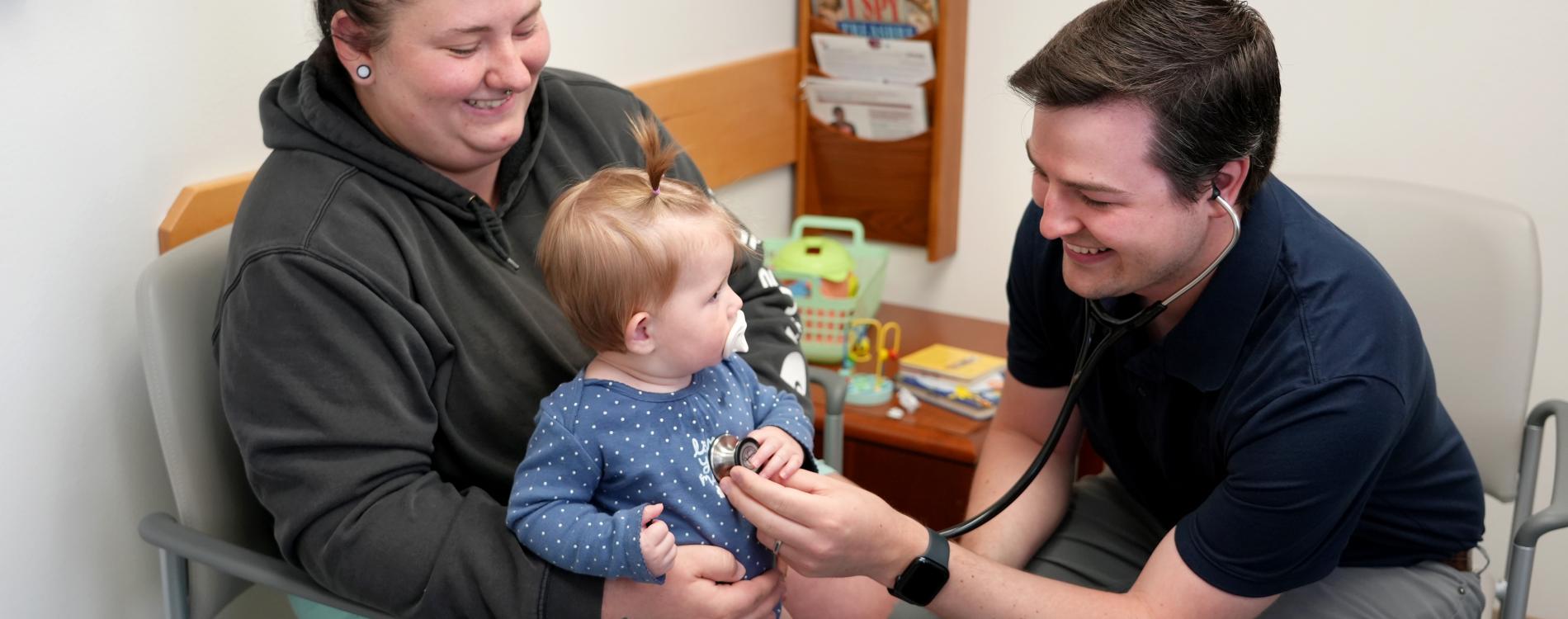 A young child is scene by a UW Department of Pediatrics Doctor in Training.